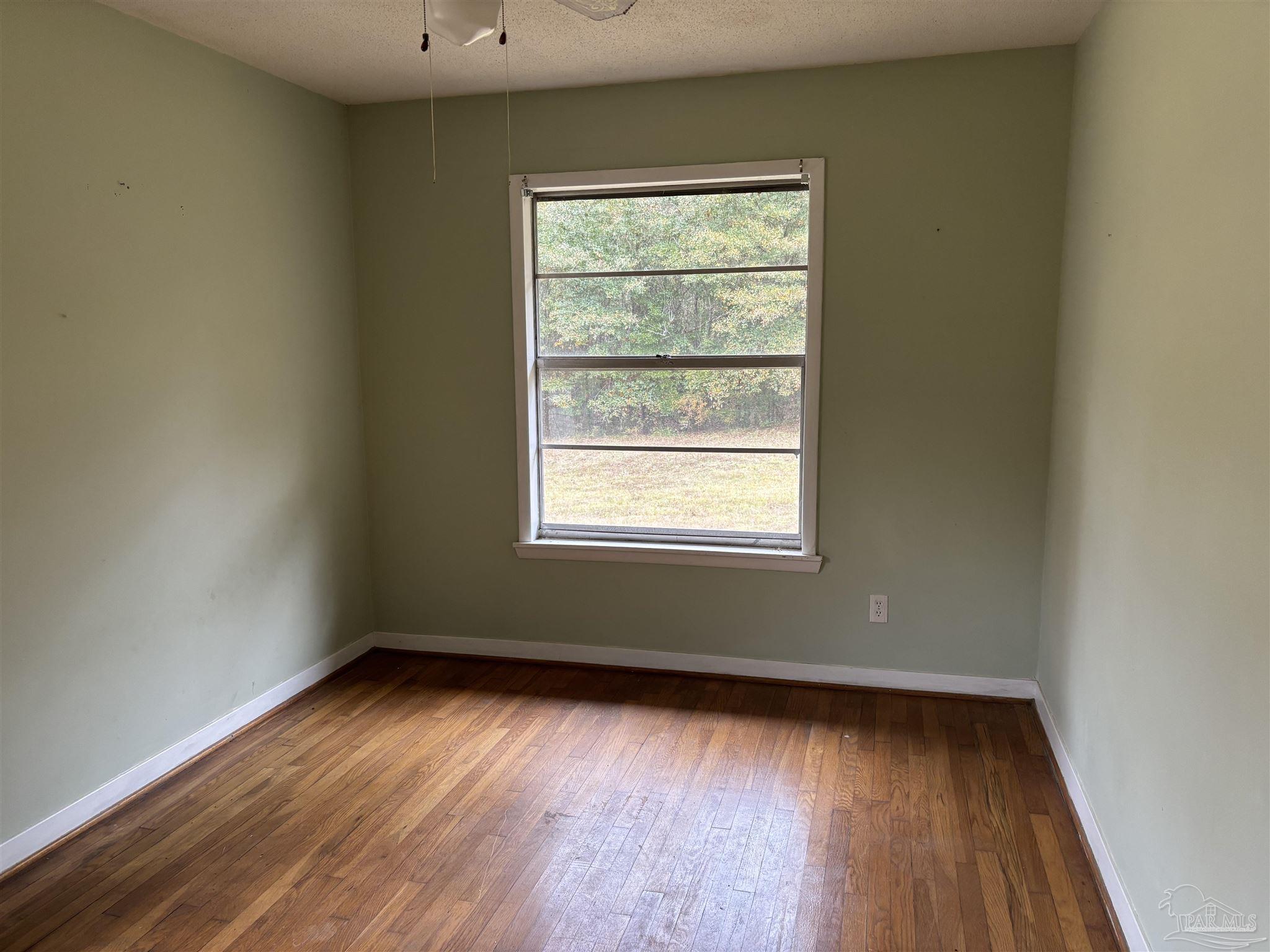 100 Brown Road McDavid, FL 32568 - Photo 12 of 20 an empty room with wooden floor and windows