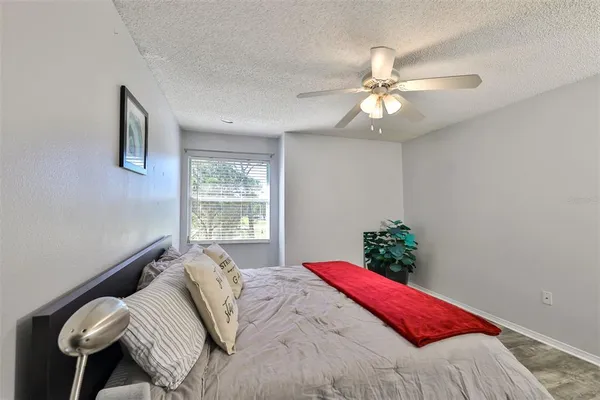 a bed sitting in a bedroom next to a window and a chandelier