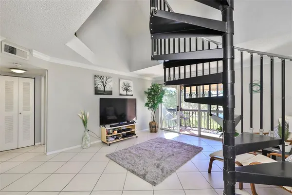 a living room with furniture a flat screen tv and a window