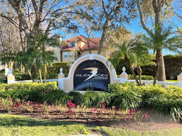 a front view of a house with a garden and trees