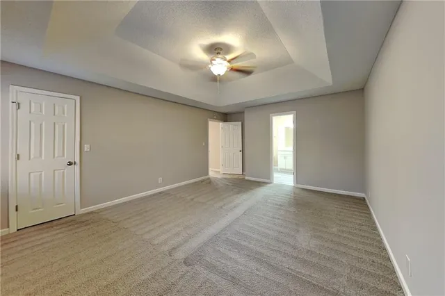 a view of an empty room with a chandelier fan