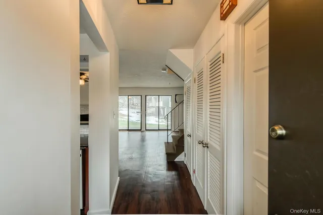 a view of a hallway with a white walls and stairs