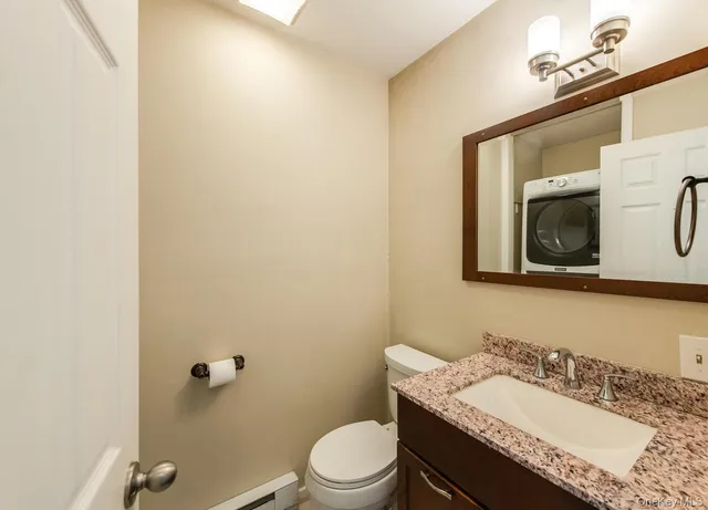 a bathroom with a granite countertop sink mirror vanity and toilet