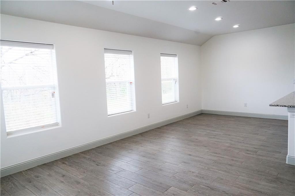 424 East Nelson Street Denison, TX 75021 - Photo 10 of 21 an empty room with wooden floor and windows