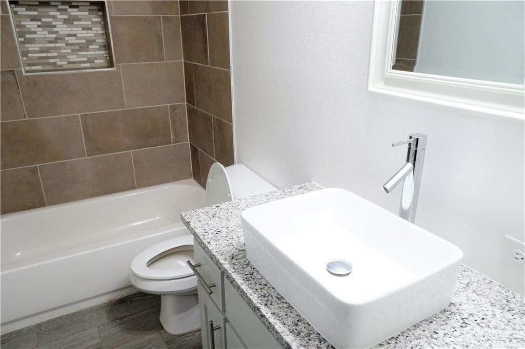 424 East Nelson Street Denison, TX 75021 - Photo 13 of 21 a bathroom with a sink a toilet and bathtub