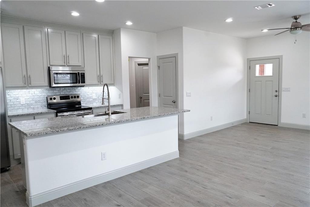 424 East Nelson Street Denison, TX 75021 - Photo 2 of 21 a kitchen with stainless steel appliances granite countertop a stove a sink and a refrigerator