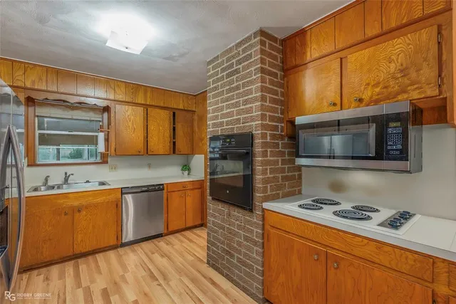 a kitchen with stainless steel appliances granite countertop a stove a sink and a microwave