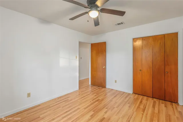 wooden floor in an empty room with a fan