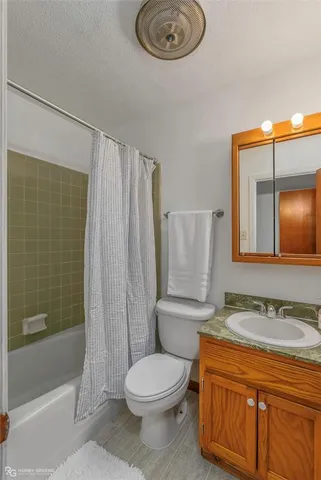 a bathroom with a granite countertop toilet sink and shower