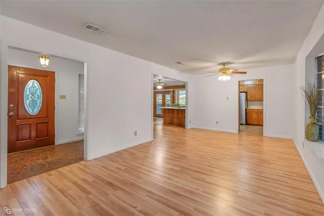 a view of a big room with wooden floor and windows