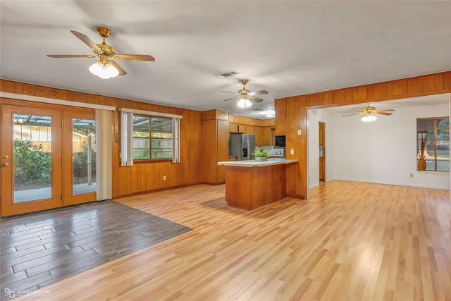 a view of a big room with wooden floor and a kitchen