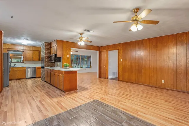 a large kitchen with cabinets and wooden floor