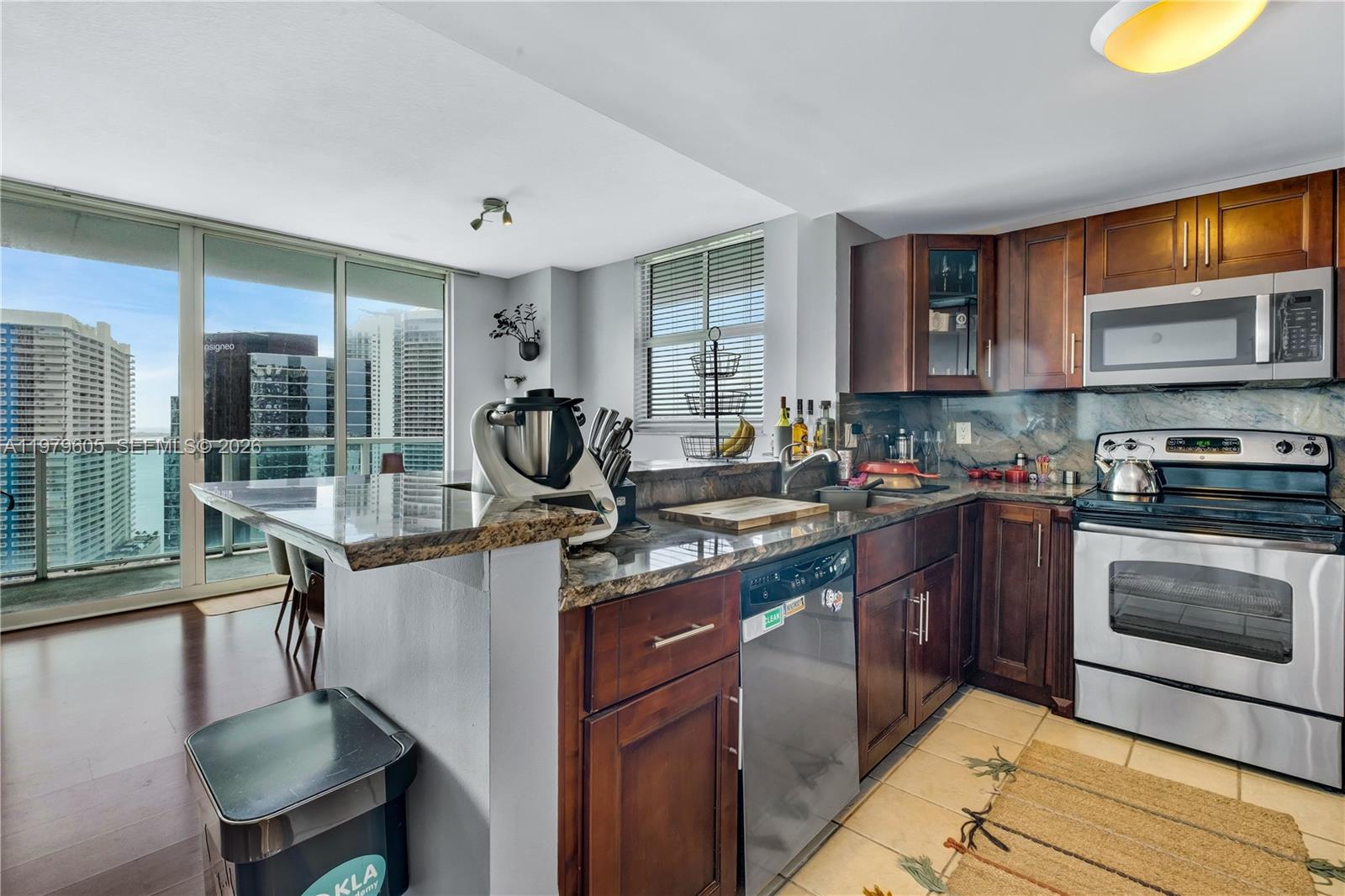 1250 South Miami Avenue, Unit 2802 Miami, FL 33130 - Photo 58 of 64 a kitchen with kitchen island granite countertop a stove a sink and a microwave