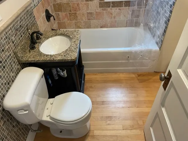 a bathroom with a granite countertop toilet sink and mirror