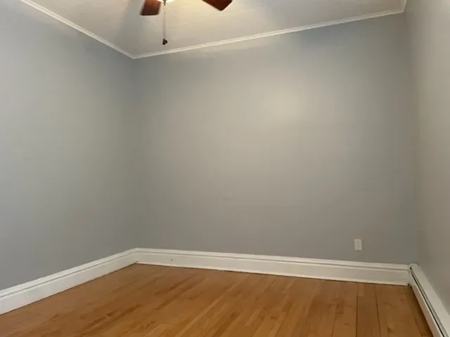 a view of an empty room with wooden floor