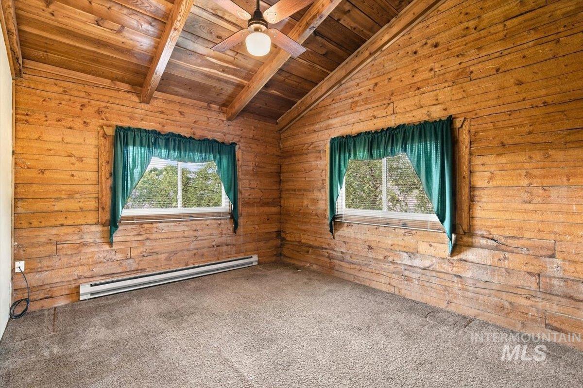 10201 Willis Road Middleton, ID 83644 - Photo 17 of 38 Vaulted wood-paneled ceiling with exposed beams, wood-plank walls, and dual windows