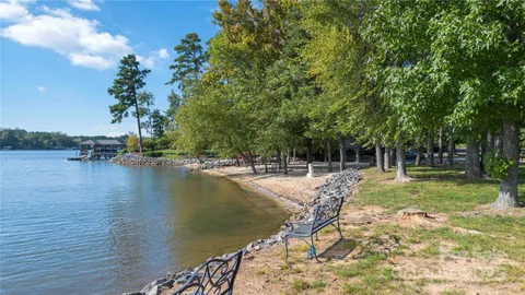 a view of swimming pool with lawn chairs and plants