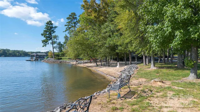 a view of swimming pool with lawn chairs and plants