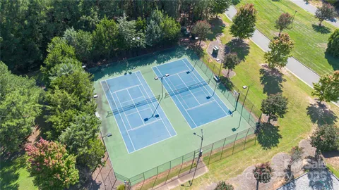 an aerial view of a house with a yard lake and outdoor seating