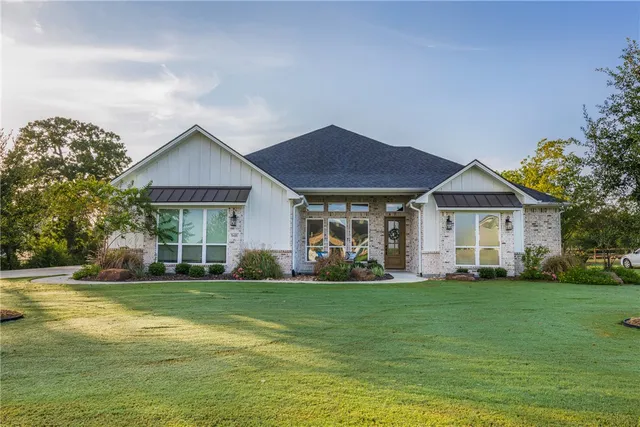 a view of a house with a yard and sitting area