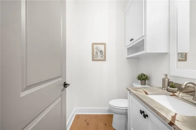 a bathroom with a granite countertop toilet sink and mirror