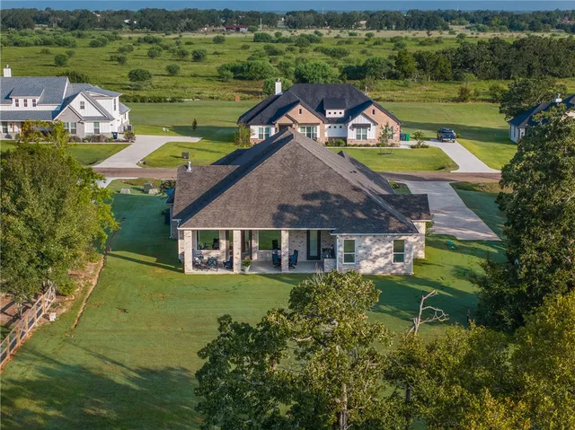 an aerial view of a house with a garden and lake view