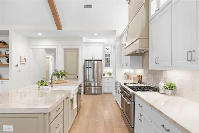 a kitchen with stainless steel appliances a sink stove and refrigerator