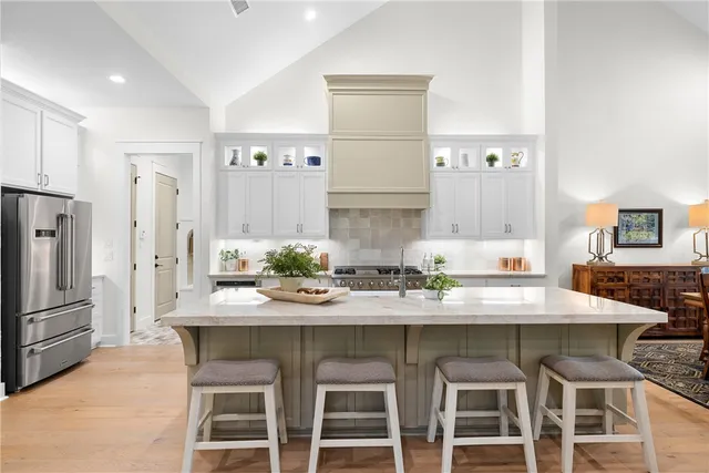 a kitchen with granite countertop a table chairs stove and refrigerator