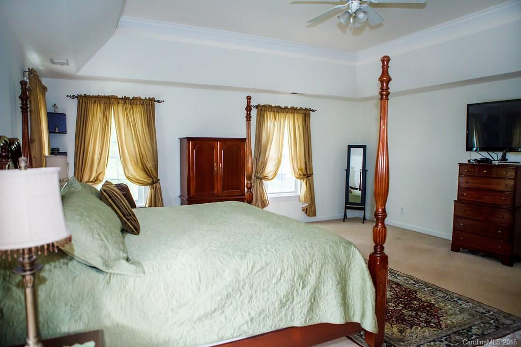 12521 Hawks Ridge Road Huntersville, NC 28078 - Photo 16 of 24 a bedroom with a bed dresser and a flat tv screen