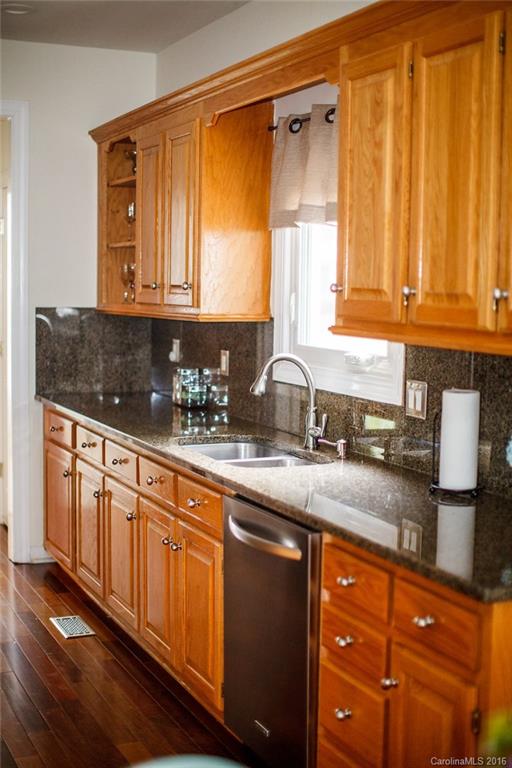 12521 Hawks Ridge Road Huntersville, NC 28078 - Photo 4 of 24 a kitchen with granite countertop wooden cabinets a sink and a window
