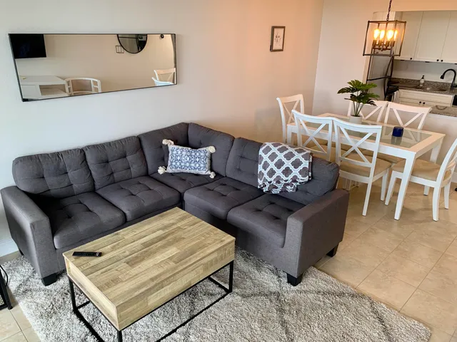 a living room with furniture a flat screen tv and kitchen view