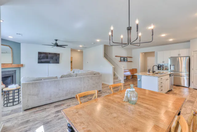 a view of a dining room and livingroom with furniture wooden floor a chandelier