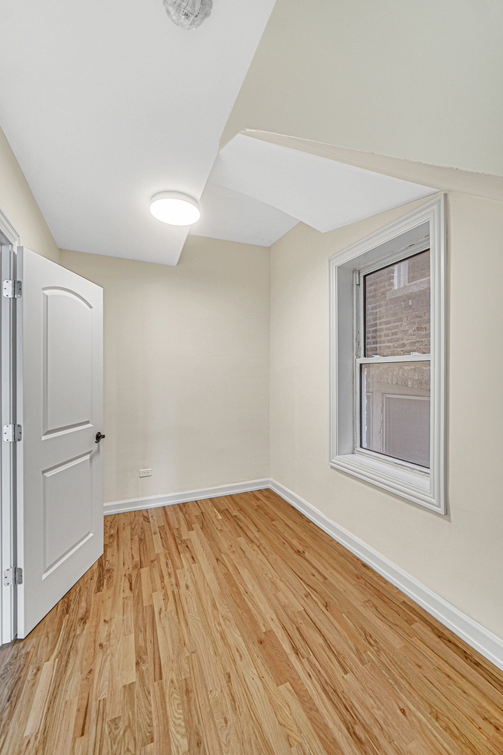 2623 West 21st Place Chicago, IL 60608 - Photo 18 of 29 a view of empty room with wooden floor and fan