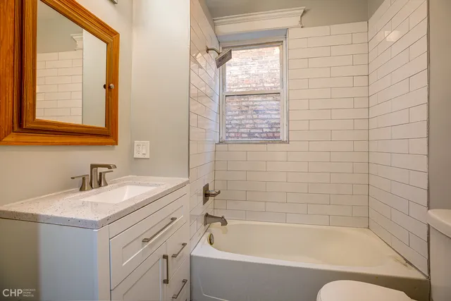 a bathroom with a granite countertop sink toilet and bathtub