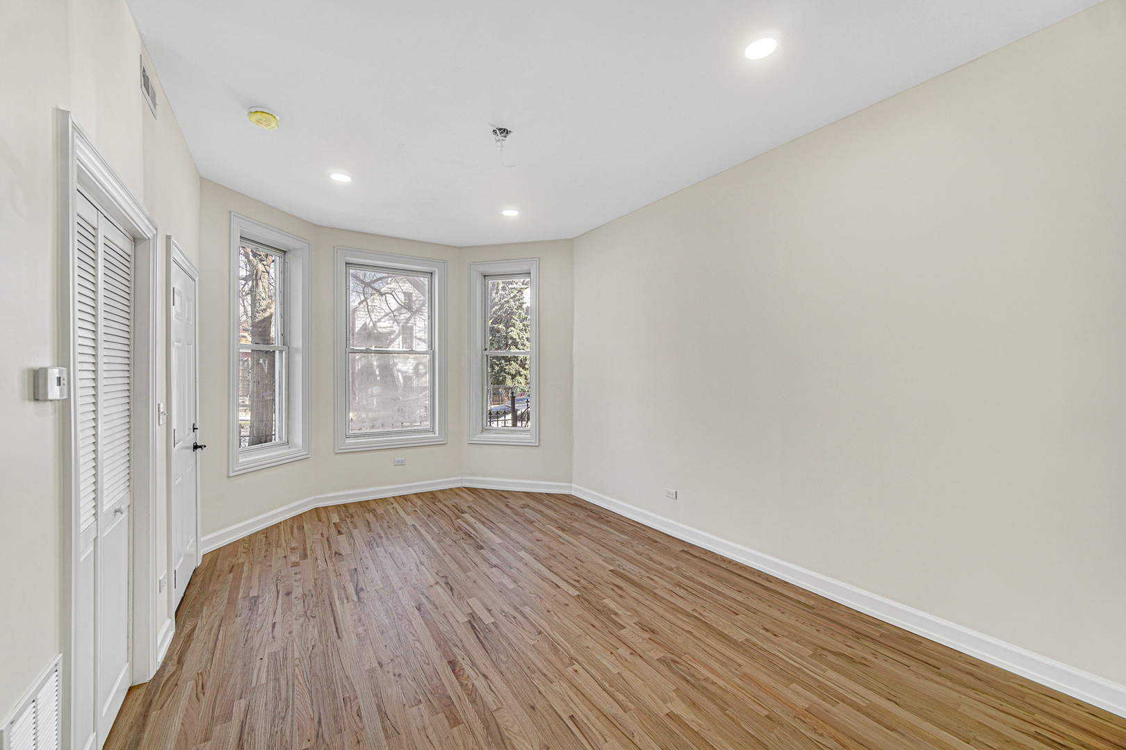 2623 West 21st Place Chicago, IL 60608 - Photo 7 of 29 a view of an empty room with wooden floor and a window