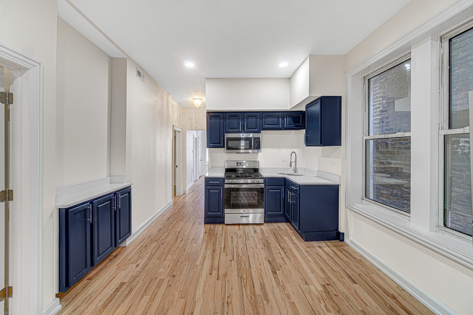 2623 West 21st Place Chicago, IL 60608 - Photo 9 of 29 a kitchen with stainless steel appliances wooden floors and wooden cabinets