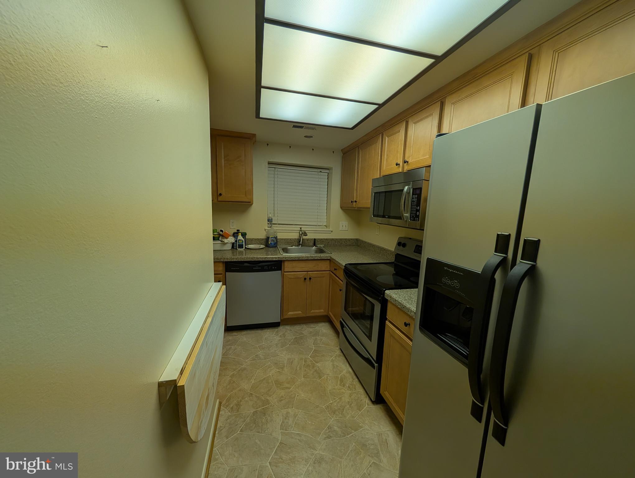 15401 Bassett Lane, Unit 452E Silver Spring, MD 20906 - Photo 20 of 26 a kitchen with sink refrigerator and microwave