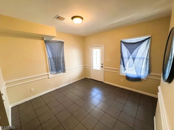 a view of an empty room with window and a bathroom