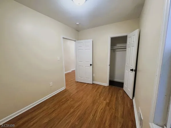 an empty room with wooden floor and closet