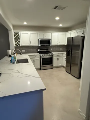 a kitchen with refrigerator and cabinets
