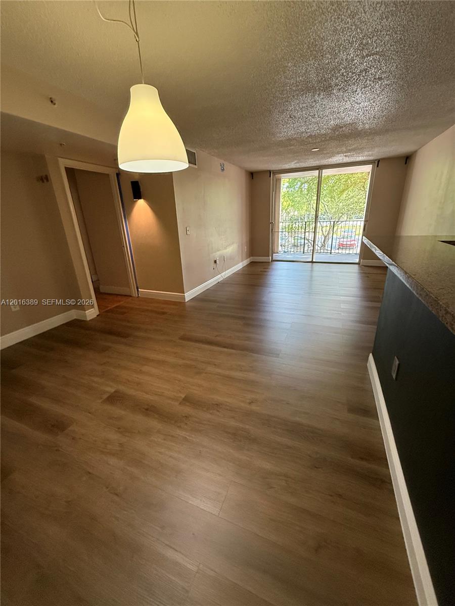 2113 Renaissance Boulevard, Unit 203 Miramar, FL 33025 - Photo 11 of 19 wooden floor in an empty room with a window