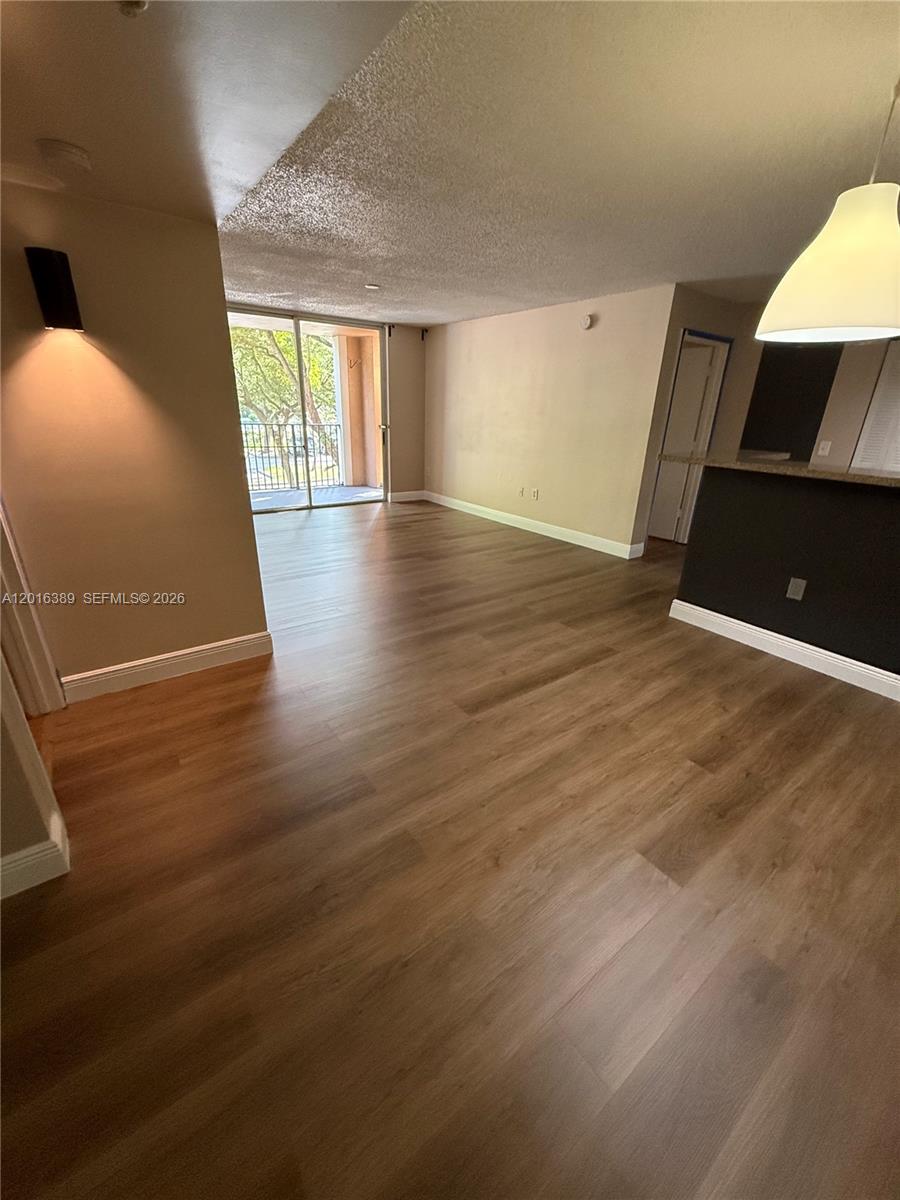 2113 Renaissance Boulevard, Unit 203 Miramar, FL 33025 - Photo 12 of 19 a view of an empty room with wooden floor and a window