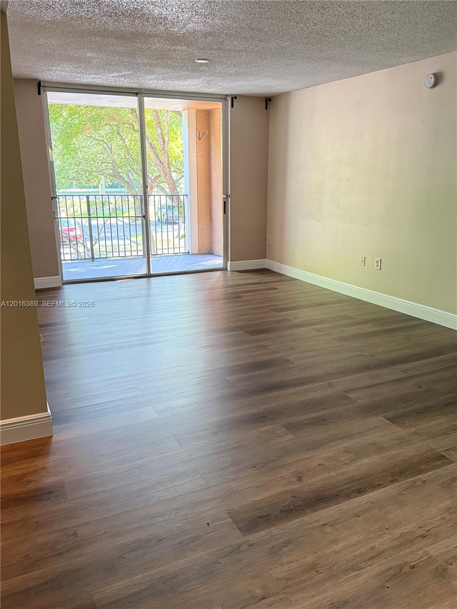 2113 Renaissance Boulevard, Unit 203 Miramar, FL 33025 - Photo 14 of 19 a view of an empty room with wooden floor and a window