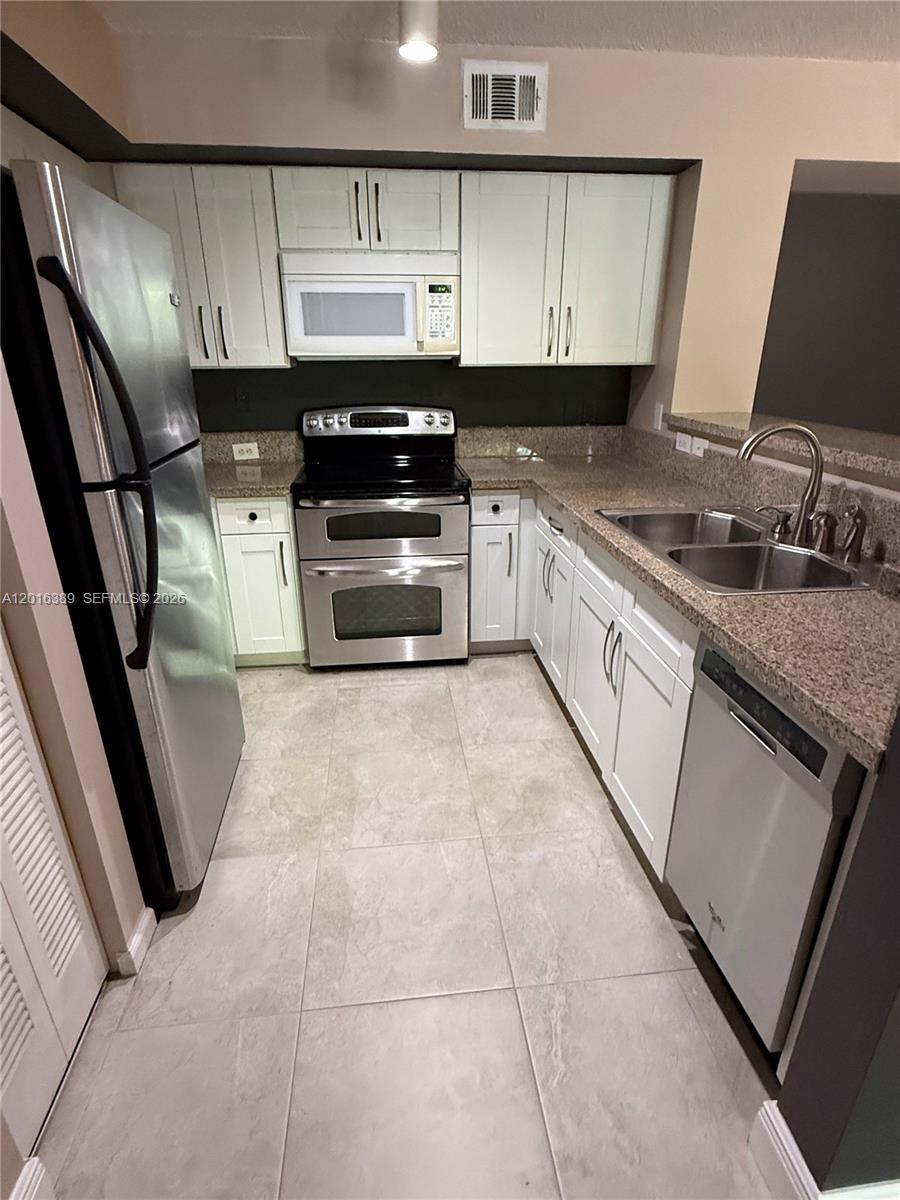 2113 Renaissance Boulevard, Unit 203 Miramar, FL 33025 - Photo 3 of 19 a kitchen with cabinets and appliances