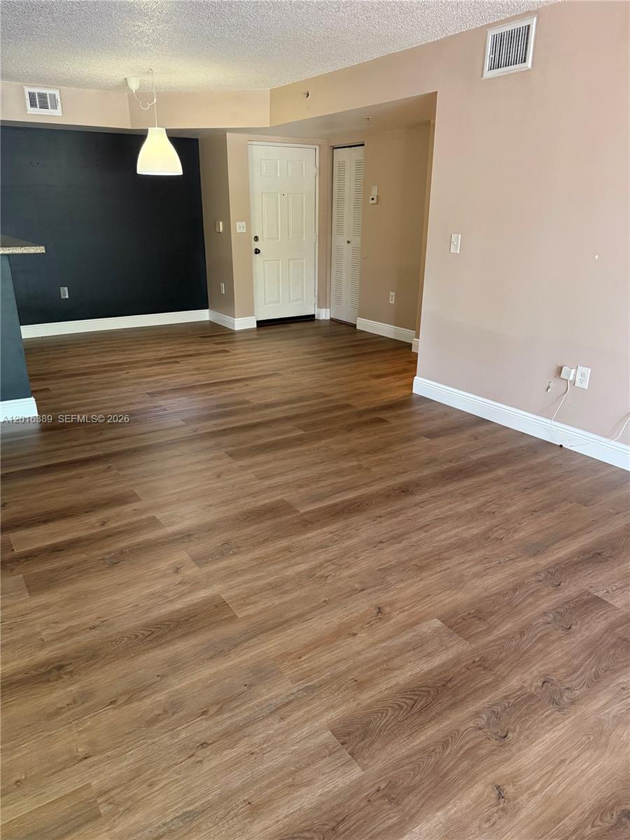 2113 Renaissance Boulevard, Unit 203 Miramar, FL 33025 - Photo 8 of 19 a view of an empty room with wooden floor