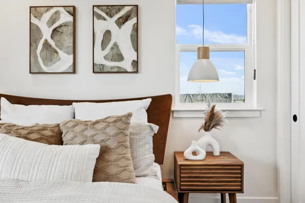 a bedroom with a bed and painting on the wall