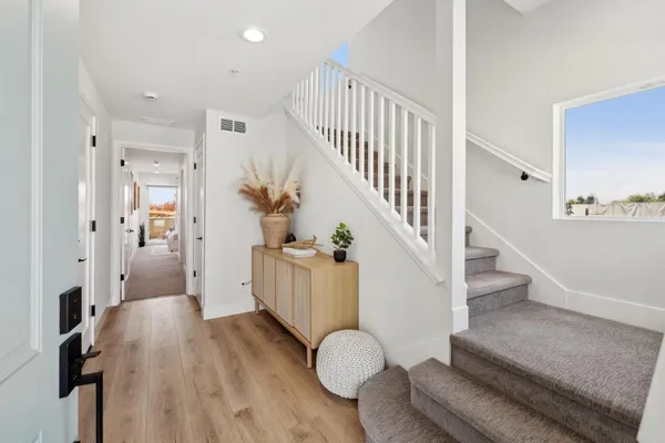a view of entryway and hall with wooden floor