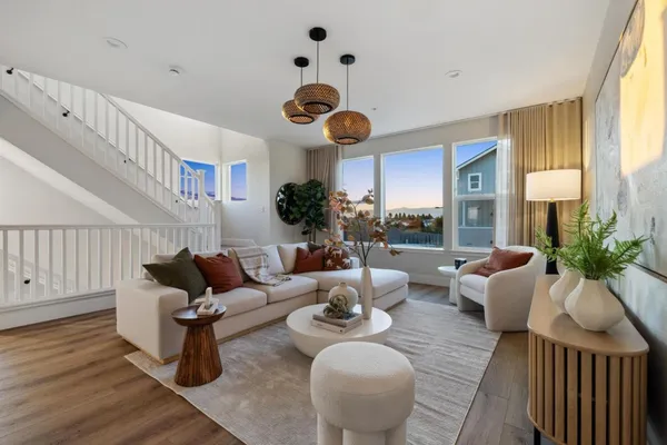 a living room with furniture kitchen view and a large window