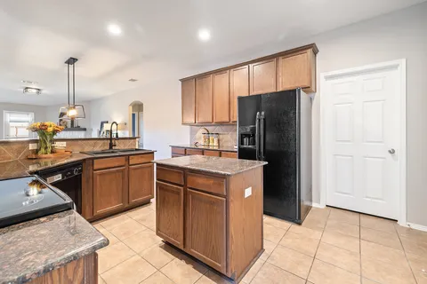 a kitchen with a stove a refrigerator and a sink