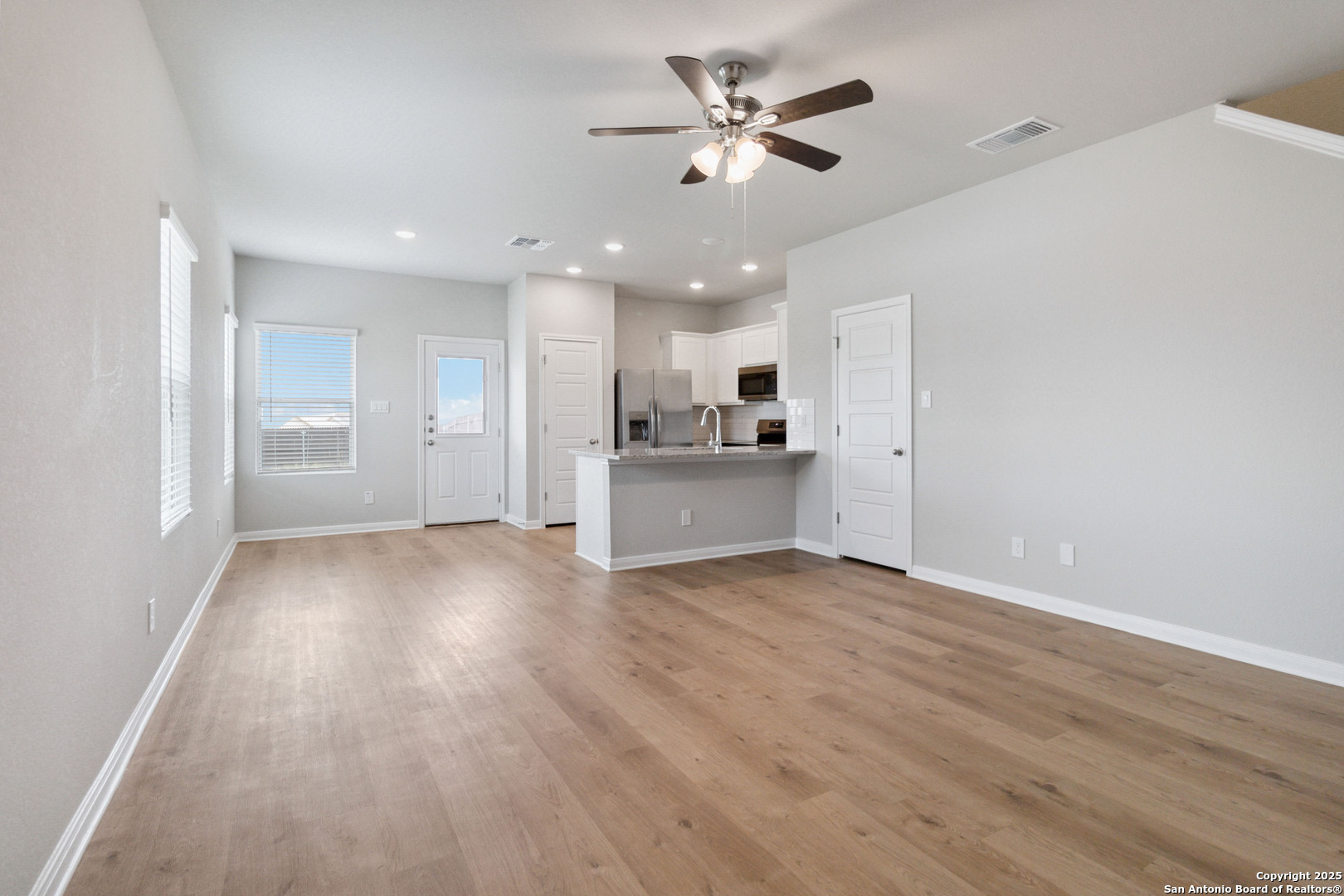 5406 Devils Gate Converse, TX 78109 - Photo 8 of 28 wooden floor in an empty room with a kitchen